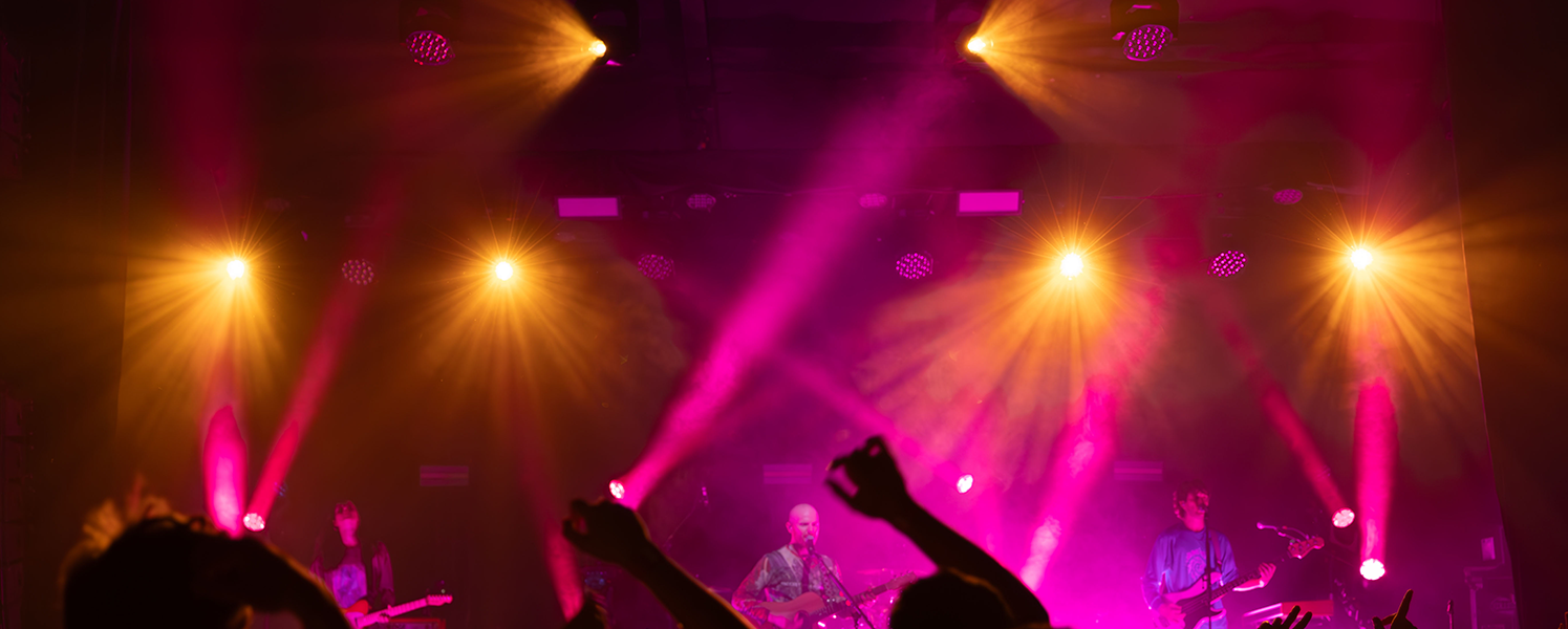 Entertainment lighting illuminating a live concert stage
